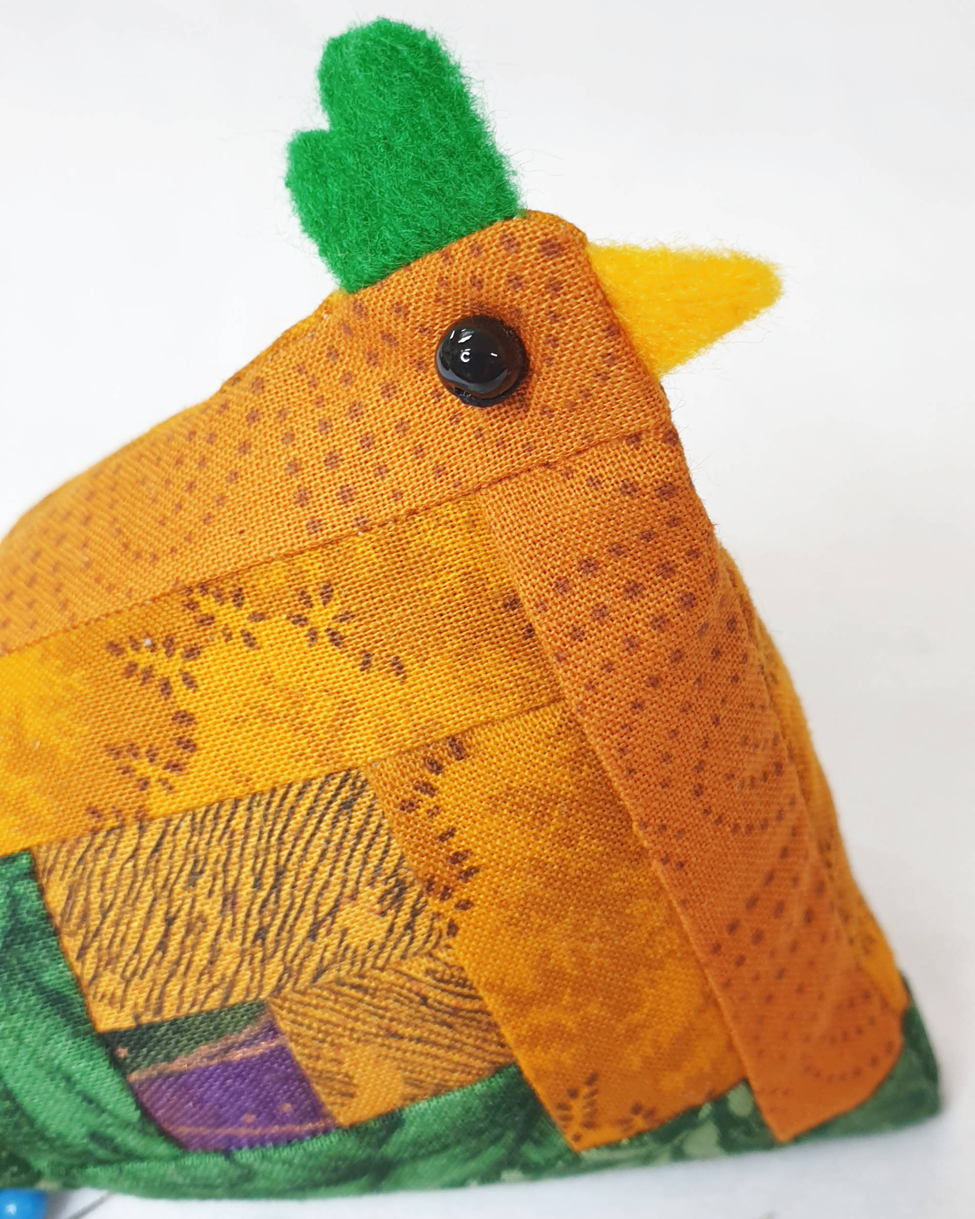 Orange and green chicken pin cushion - Closeup of face