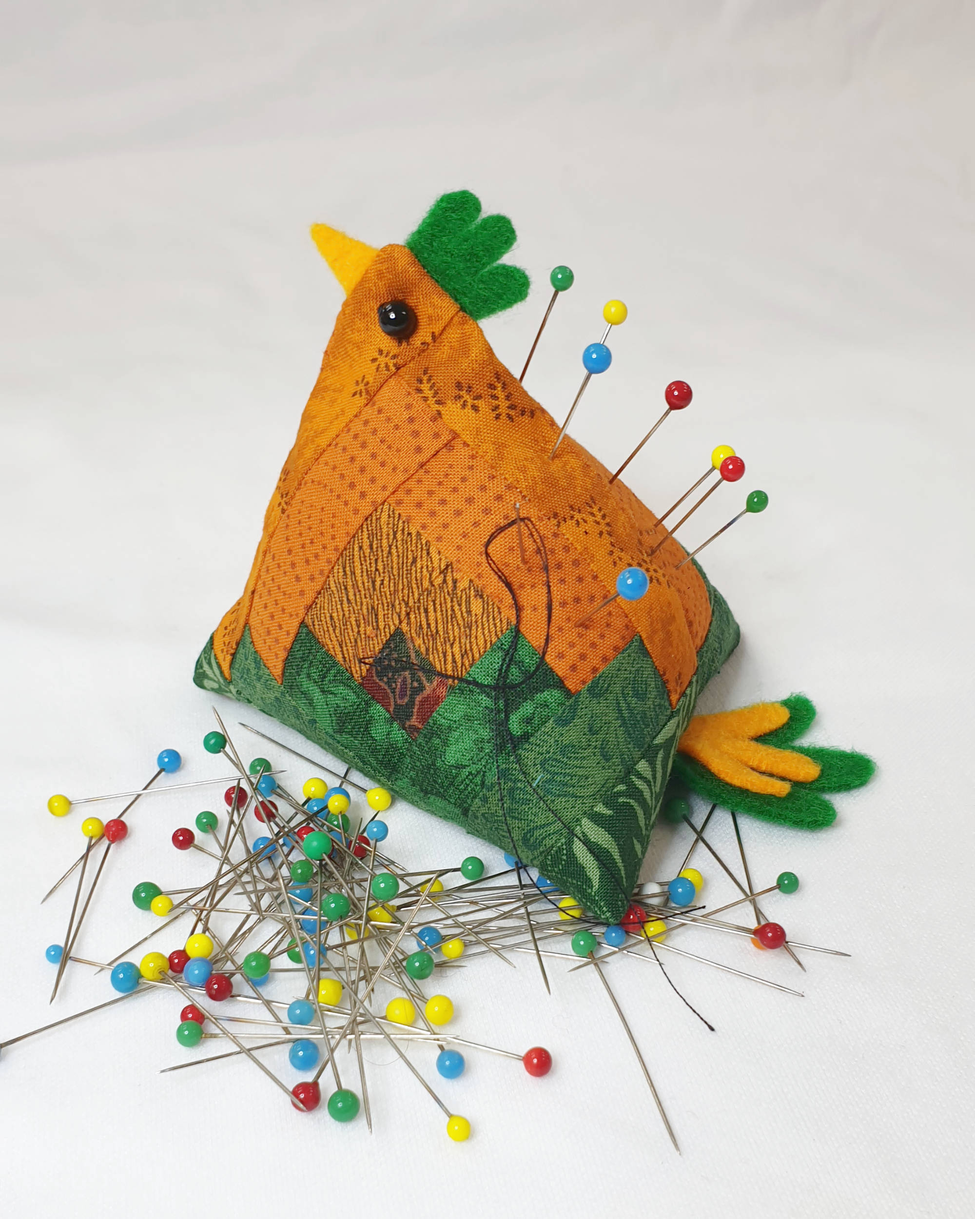 Orange and green chicken pin cushion - Facing left